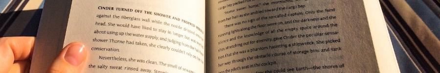 Person reading the book Cinder 